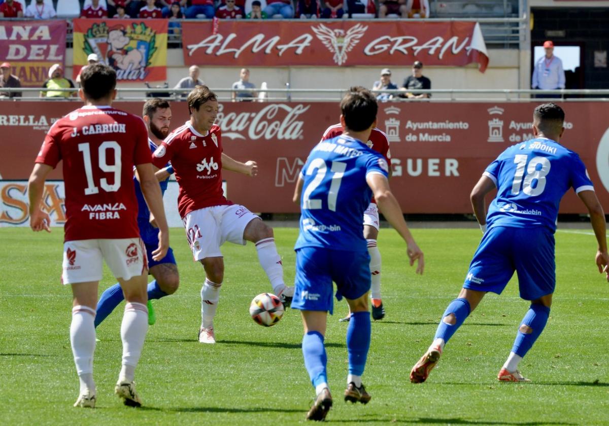 Pina, jugador del Real Murcia, juega el balón cerca de su compañero Juanmi Carrión.