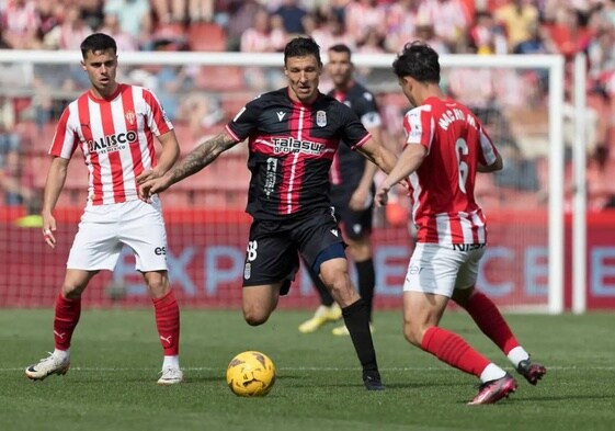 El pivote Damián Musto, rodeado, en la derrota en El Molinón (1-0).