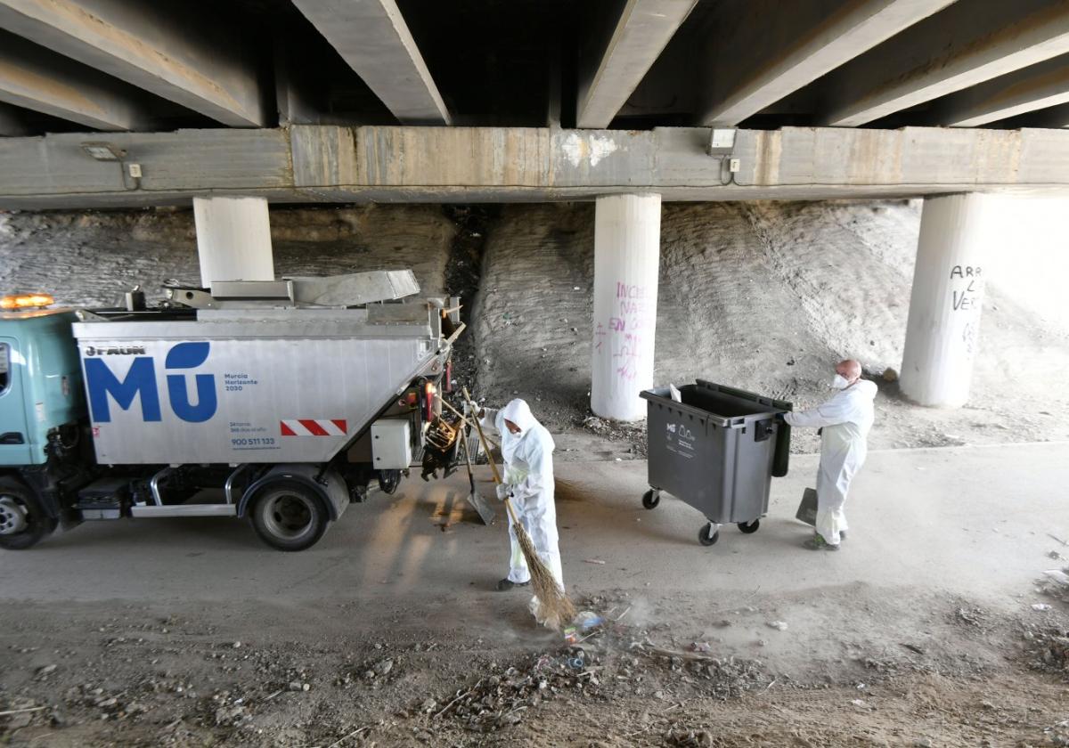 Operarios de la concesionaria limpian la zona ocupada por el asentamiento.