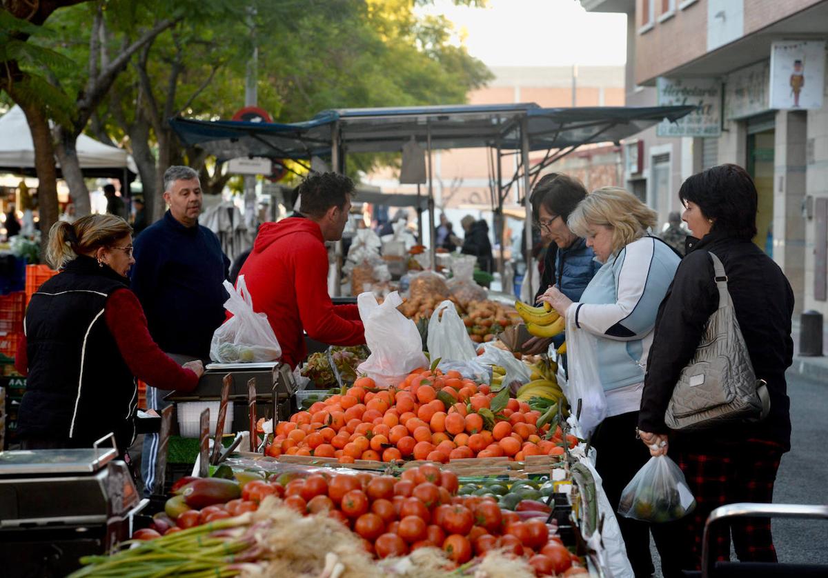 Varios clientes adquieren productos en el mercado semanal de Espinardo.