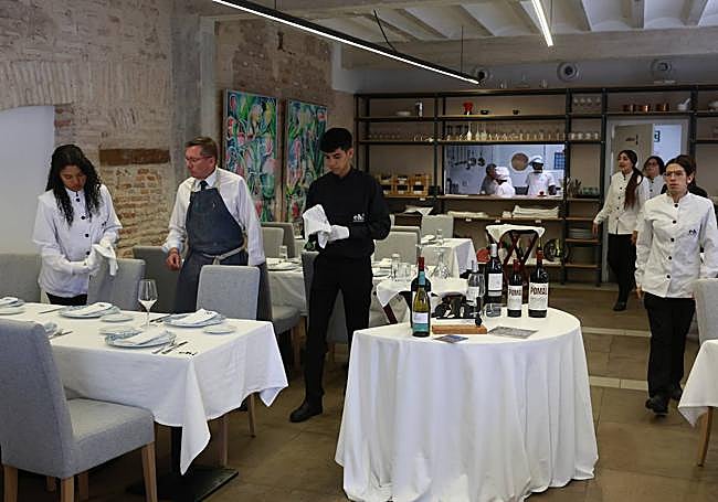 Profesores y alumnos dan los últimos retoques al comedor antes de empezar el servicio.