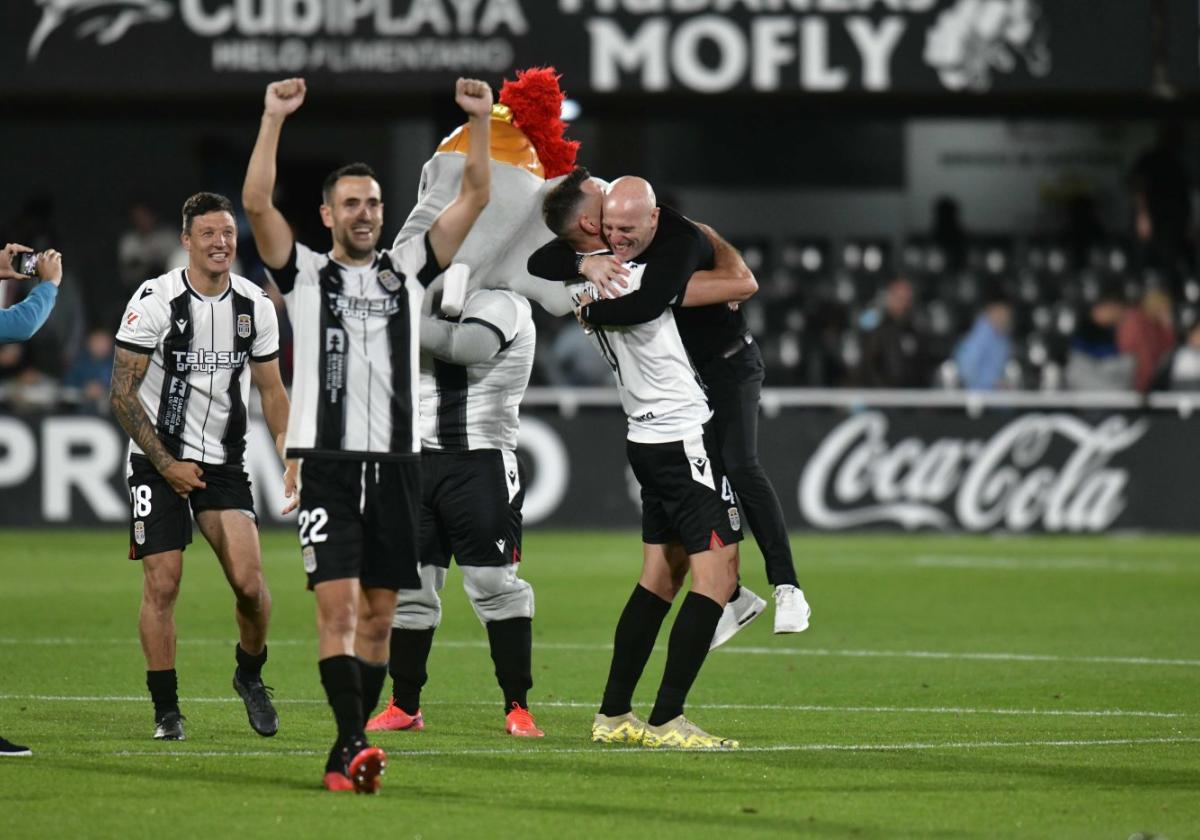 Damián Musto y Kiko Olivas celebran la victoria del pasado sábado al Alcorcón, con el capitán Pedro Alcalá y el entrenador Julián Calero fundidos en un abrazo al fondo.