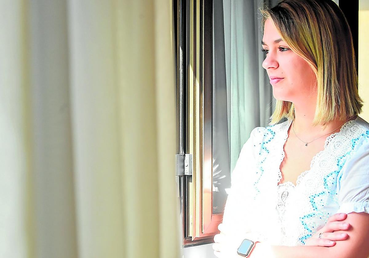 Toñi Egea mira por la ventana de su casa en Murcia, donde vive con su madre de acogida.