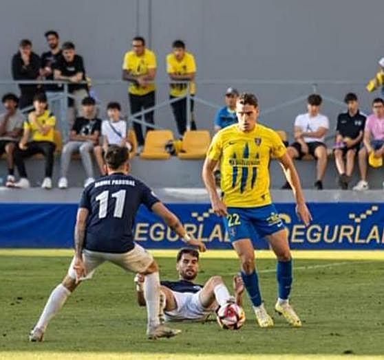 Mendi arrebata el balón al delantero Chema Moreno caído sobre el césped.