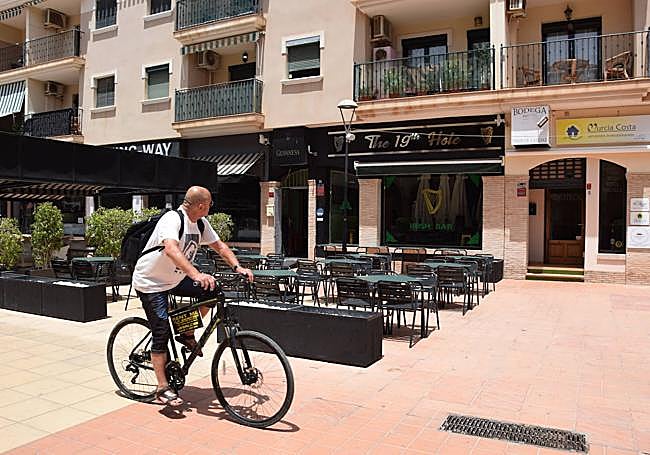 Un vecino de Los Alcázares pasea ante la terraza del bar irlandés.