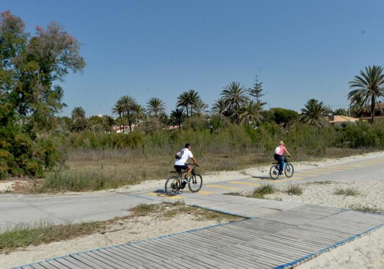 Dos ciclistas circulan sobre los restos de la antigua carretera antes de que Costas iniciara sus obras de demolición.