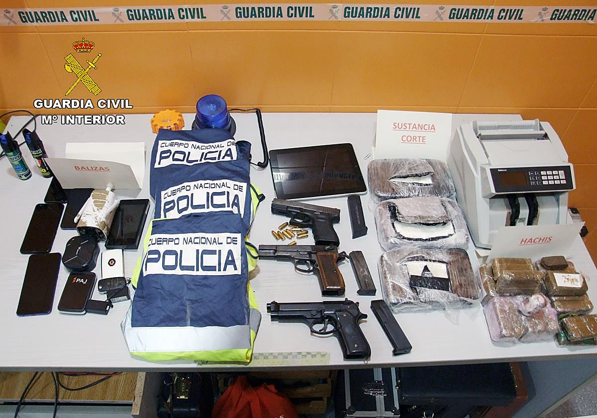 Chalecos, armas y drogas incautadas durante el registro.