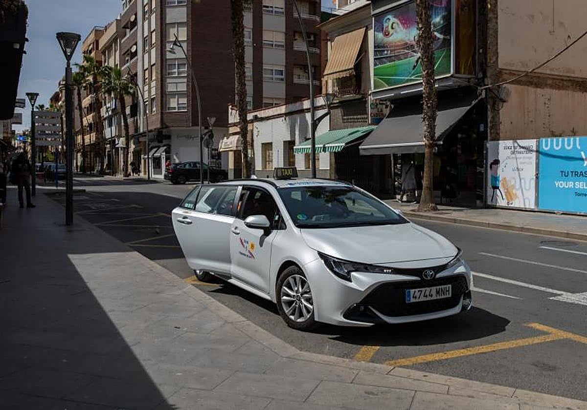 Un taxi recoge a un pasajero en la calle Ramón Gallud de Torrevieja.