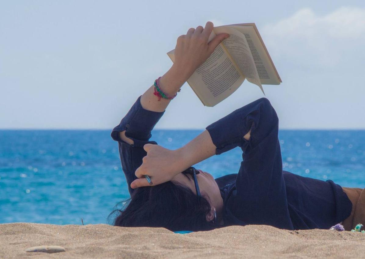 Imagen secundaria 1 - 1. Cada participante encontró el mejor espacio para disfrutar de una lectura sin distracciones. 2. Una lectora, leyendo frente al mar y protegiéndose del sol. 3. Esmeralda Berbel escuchó con atención a los lectores en los diferentes círculos de conversación realizados.