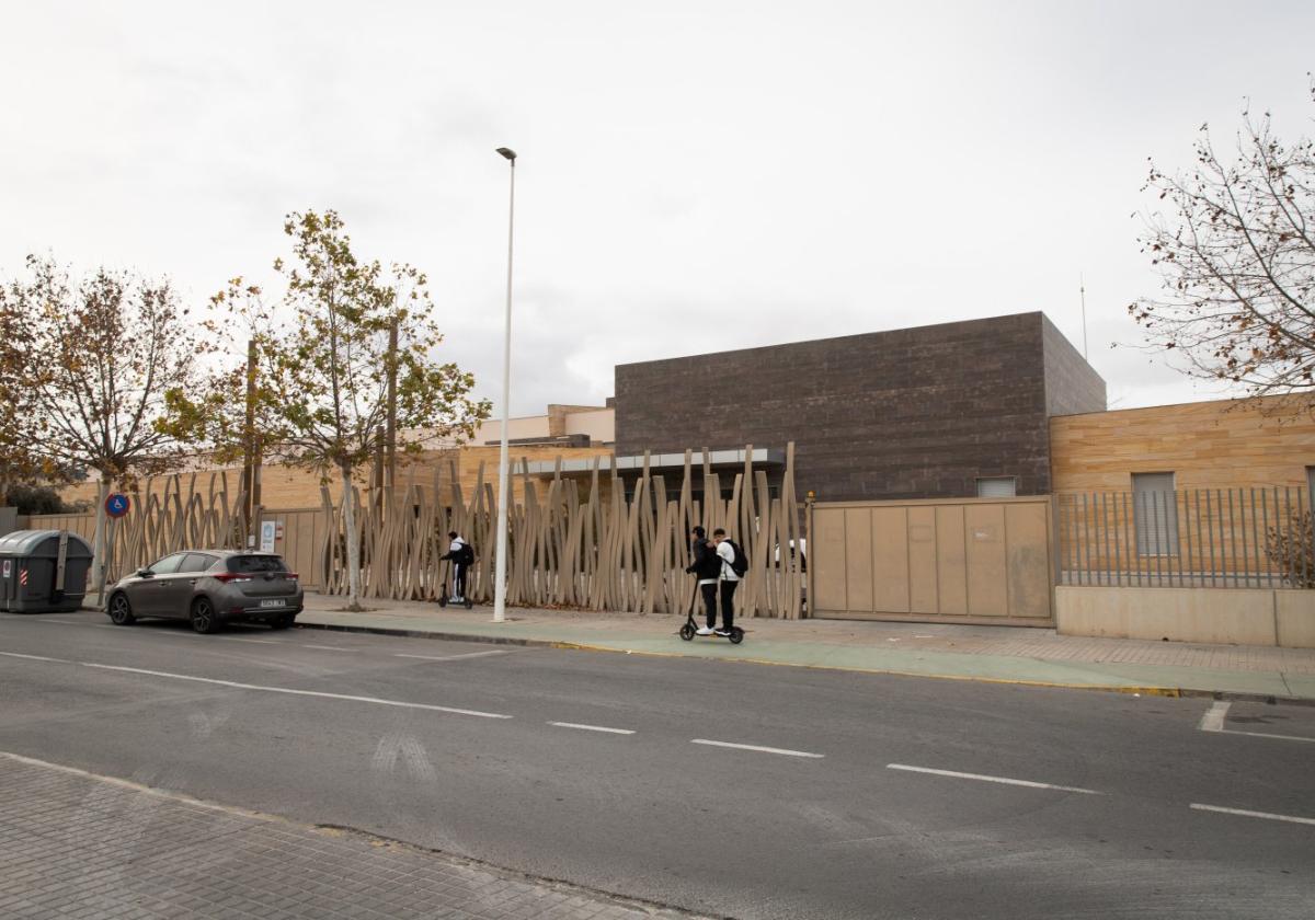 Dos jóvenes pasan en patinete por delante del centro Delfina Viudes de Torrevieja.