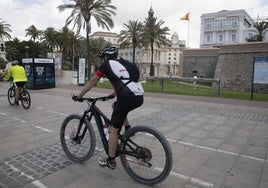 Dos ciclistas pasan frente al aparcabicis del puerto, en desuso desde hace más de una década.