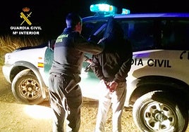 Un agente de la Guardia Civil, junto al detenido.