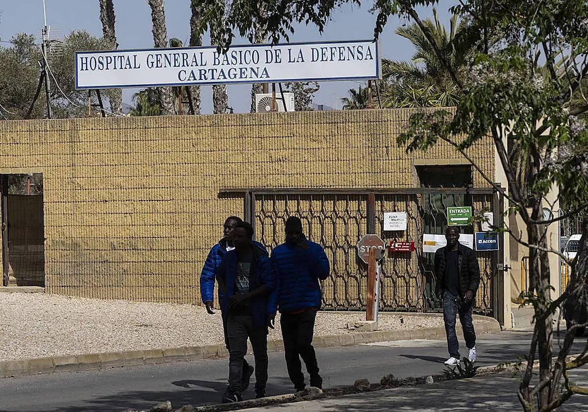 Cuatro inmigrantes salen del campamento del Hospital Naval, en una imagen de archivo.