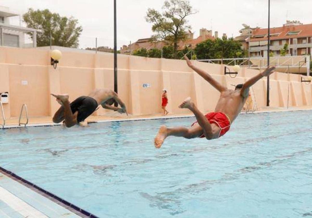 Dos jóvenes se lanzan a una piscina, en una imagen de archivo.