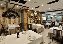 Personal de sala prepara una de las mesas en el restaurante.