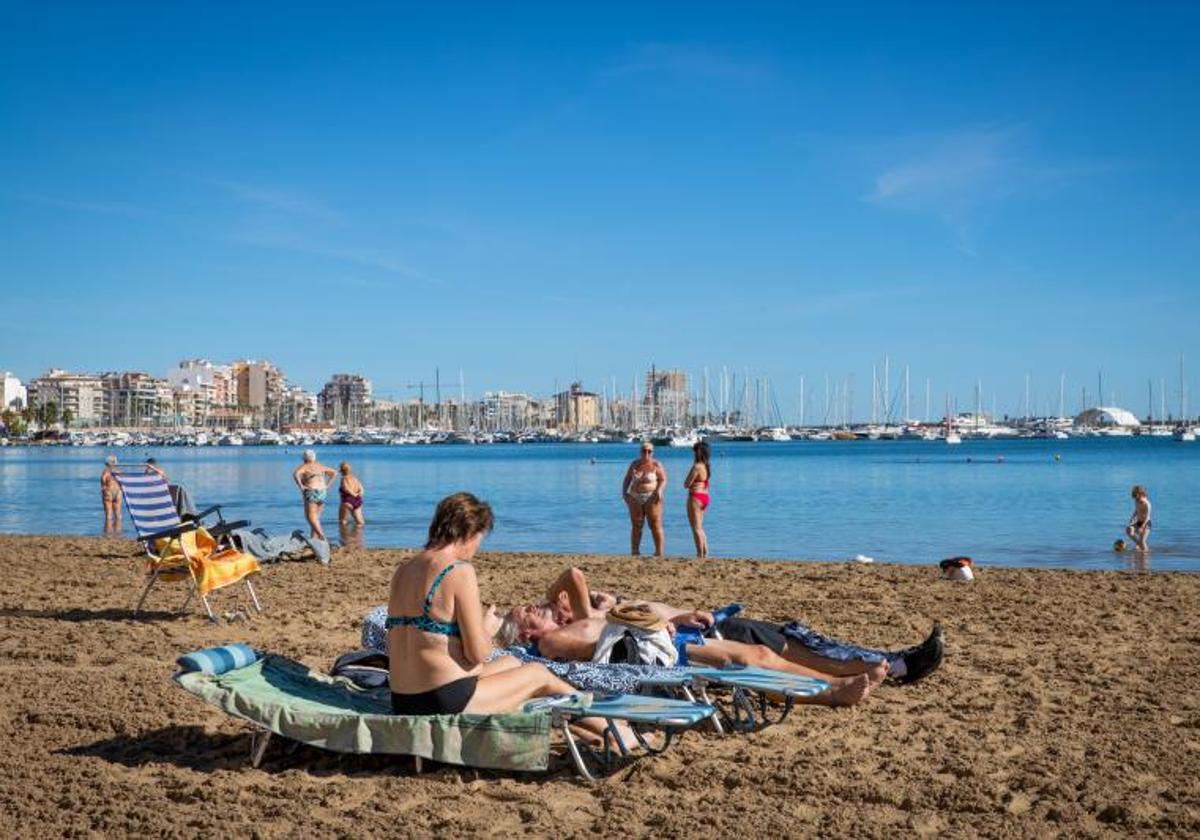 Bañistas disfrutan de un día de sol en la playa del Acequión de Torrevieja.