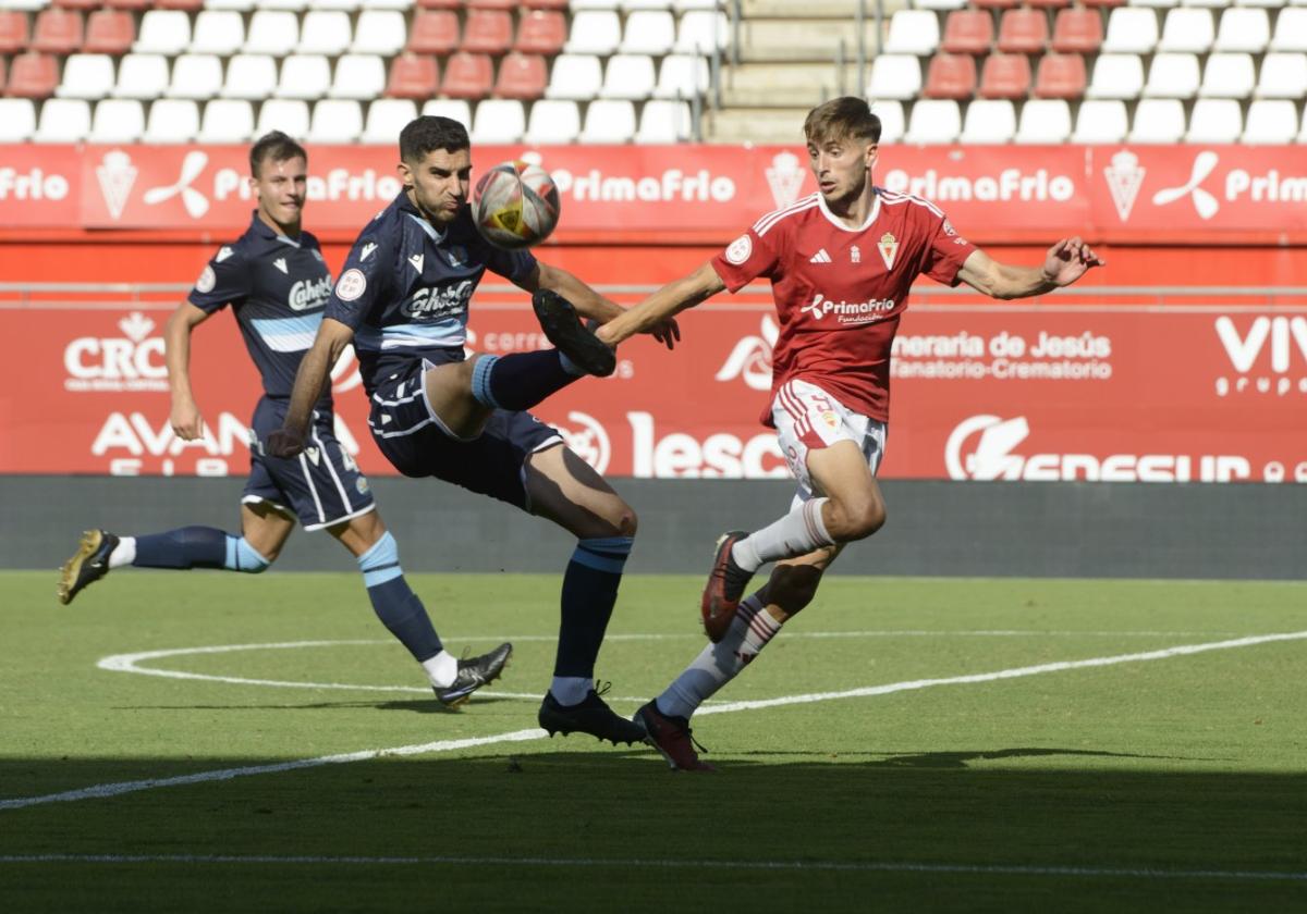 Un defensa del Coria despeja el balón ante Ángel García.