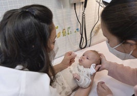 Una enfermera administra la vacuna del rotavirus, por vía oral, a un bebé.