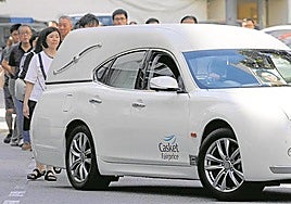 El coche fúnebre traslada los restos de Audrey Fang, seguida por familiares y amigos.