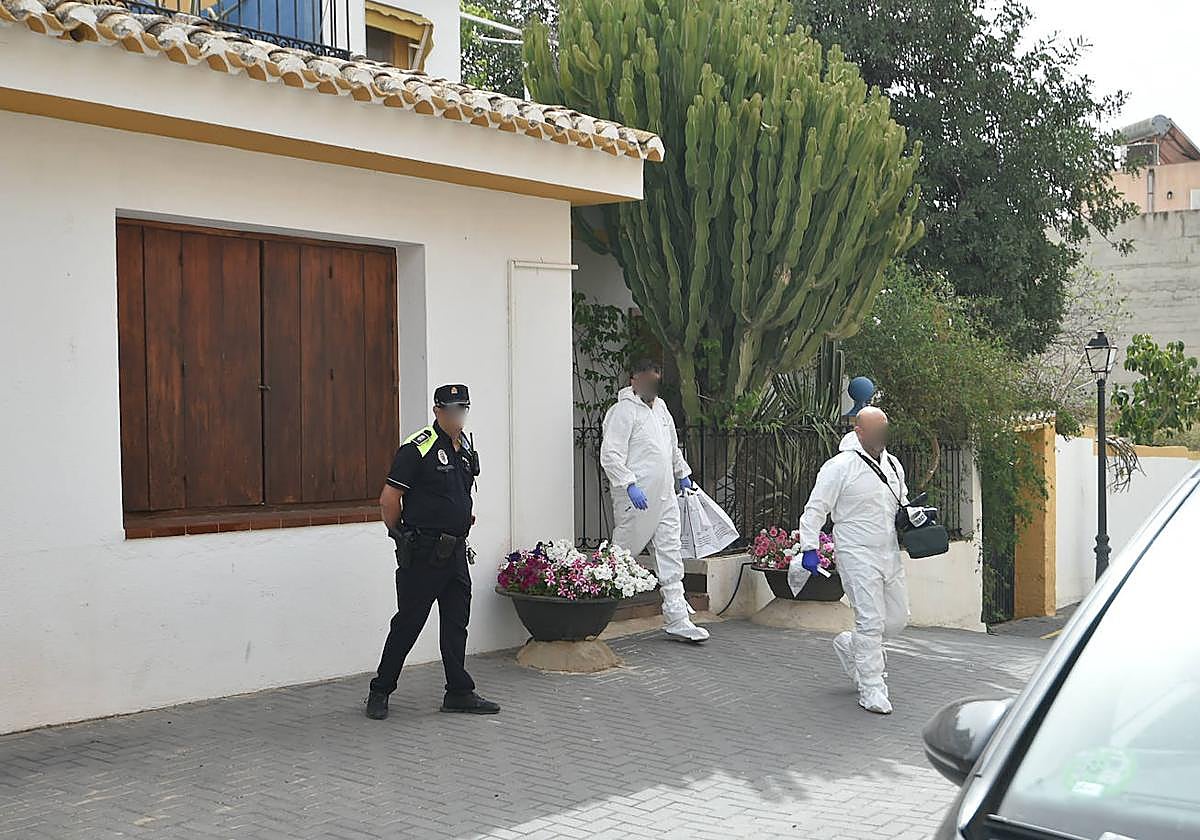 Agentes de la Policía Científica salen de la vivienda donde ocurrieron los hechos, este jueves por la mañana.