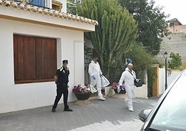 Especialistas del Servicio de Criminalística de la Guardia Civil salen de la vivienda donde se produjo el parricidio.