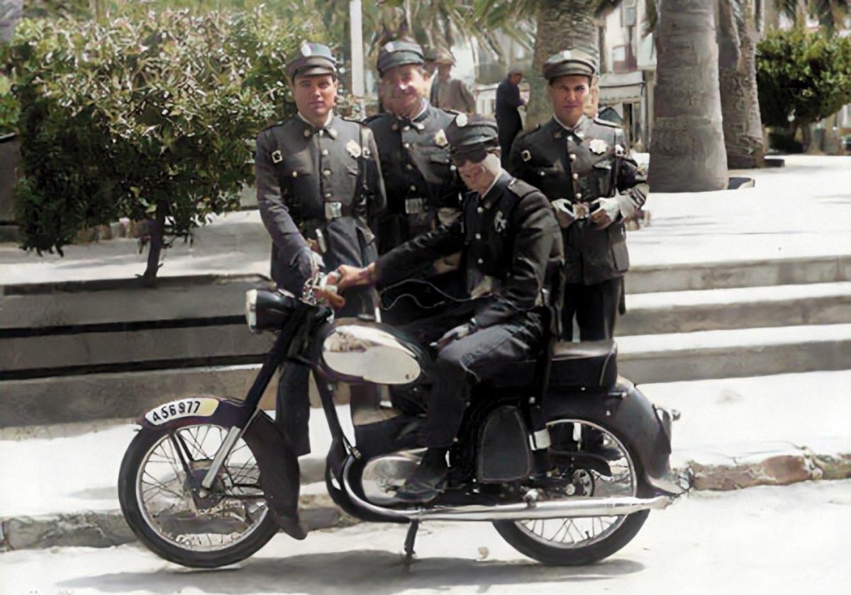 Un grupo de agentes se fotografía junto a una moto en la plaza de la Constitución en los años 60.