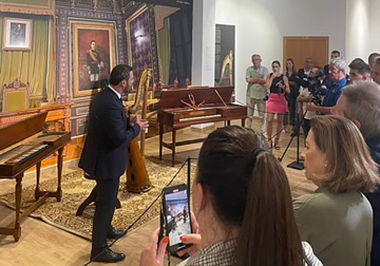 Víctor Javier Martínez, durante una visita guiada a la exposición; detrás de él, un clavicordio.
