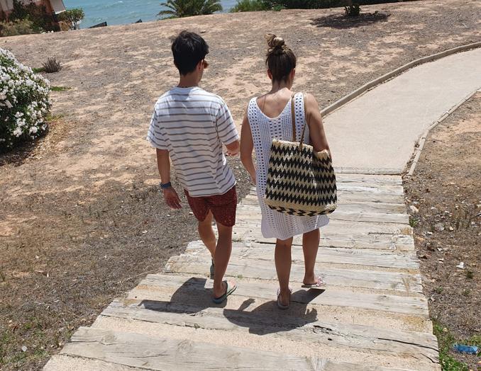 Una pareja baja las escaleras camino de la playa de Barranco Rubio.