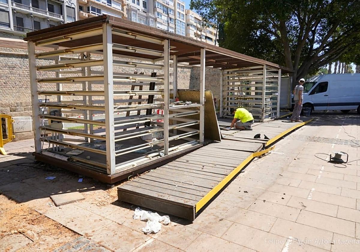 Obreros desmontan la caseta de información turística dañada.