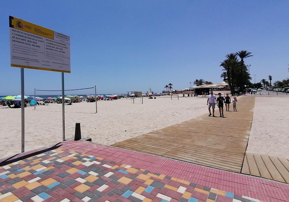 Un grupo de bañistas camina sobre la nueva pasarela sobre la desembocadura del río Nacimiento en Campoamor.