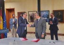 Juan María Vázquez, consejero de Universidades y el rector de la Universidad de Murcia, José Luján se dan la mano en la firma para el nuevo convenio.