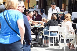 Un camarero atiende una mesa en la Plaza de las Flores de Murcia.