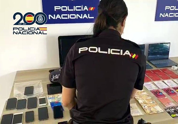 Una agente de la Policía Nacional con los efectos incautados.