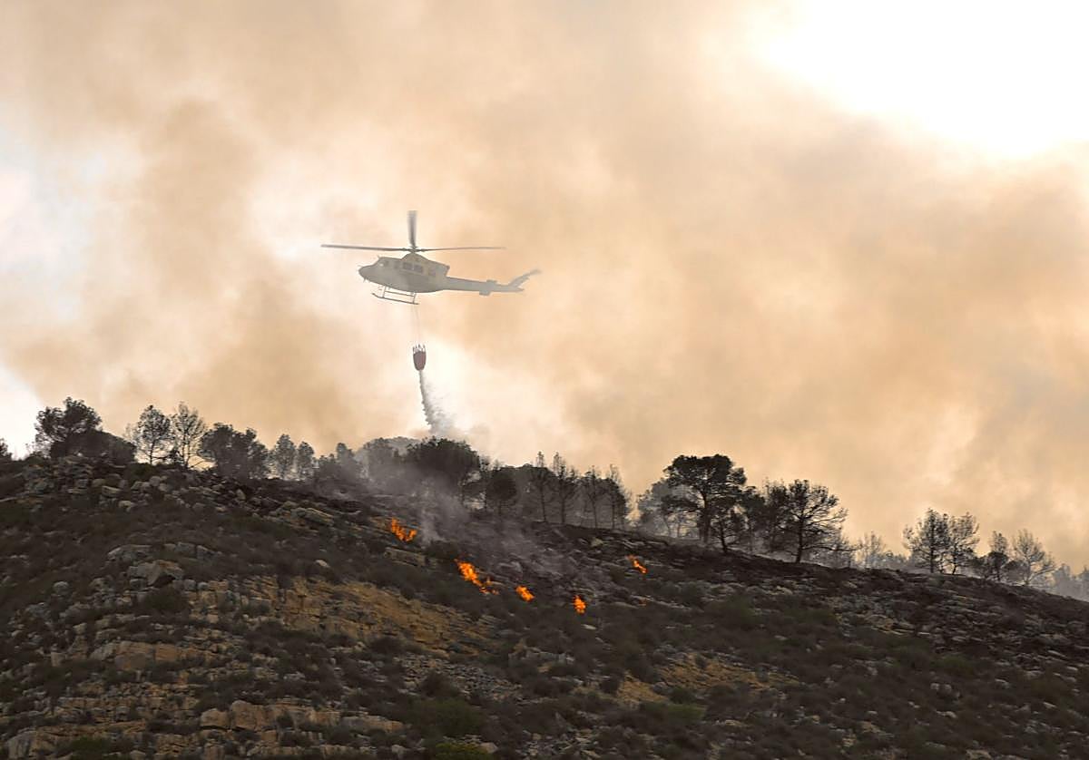 Uno de los helicópteros que participan en las labores de extinción, este jueves por la mañana.