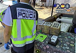Un agente de la Policía Nacional con la droga intervenida.