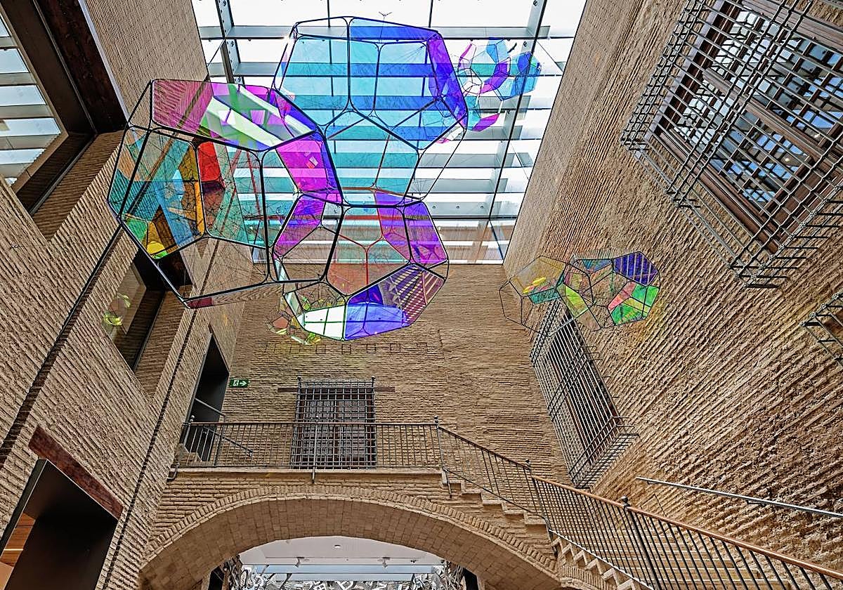 Instalación de nubes de Tomás Saraceno y, debajo, parte de la instalación de Jaume Plensa 'El ombligo'. El vestíbulo del CAHH tiene 16 metros de altura.