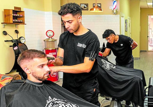 Isidro Vela trabajando en su barbería, ubicada en la avenida Juan Carlos I de Santo Ángel.