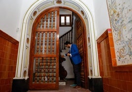 El arquitecto Enrique Miñarro observa la balaustrada de madera maciza en el zaguán del edificio Bertrand.