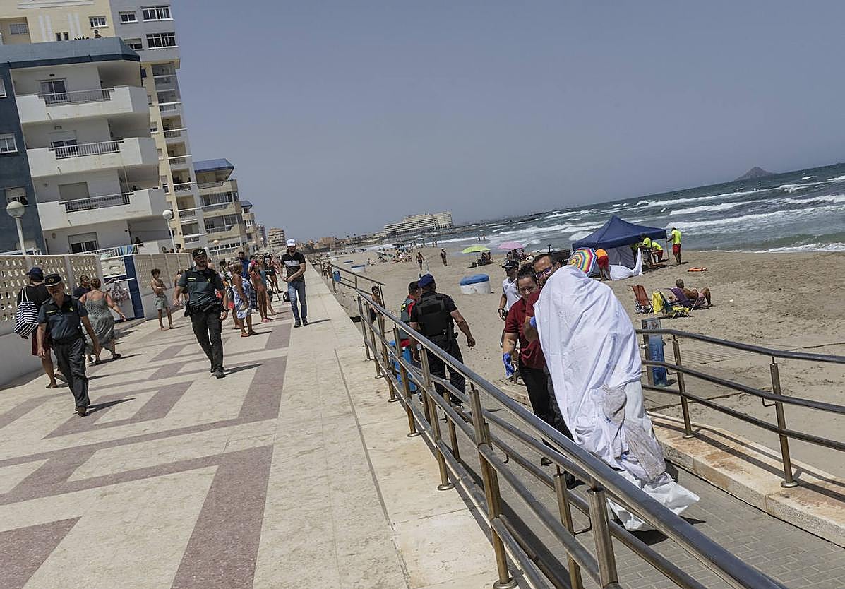 Agentes y personal funerario proceden al levantamiento del cadáver tras rescatarlo del agua este martes.