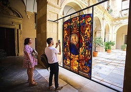 Dos visitantes fotografían la vidriera de San Pedro, instalada en el patio del Palacio Episcopal.