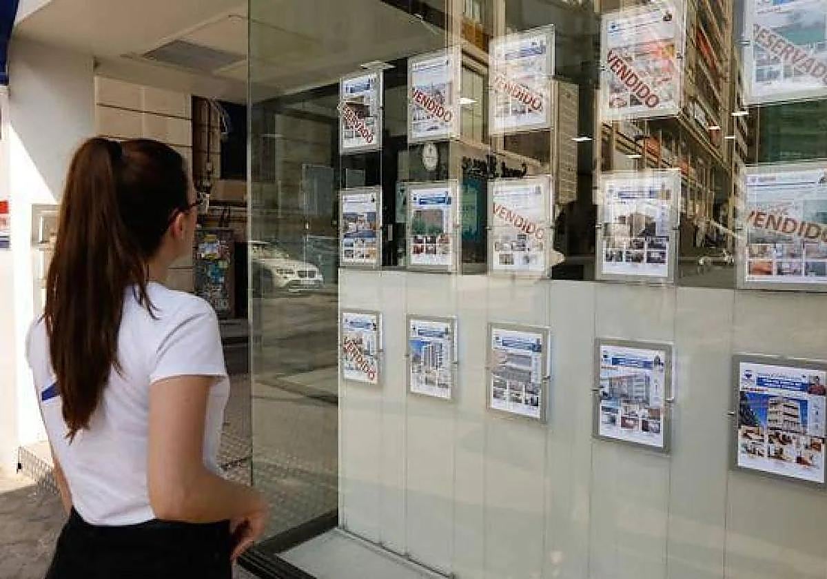 Una vecina de Murcia consulta ofertas inmobiliarias en un escaparate, en una imagen de archivo.