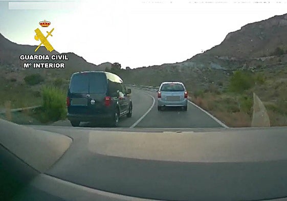 La furgoneta adelantando a un coche en una curva sin visibilidad y con línea continua.