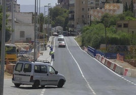 Un par de obreros dan retoques a la acera del puente construido en la carretera de Canteras.