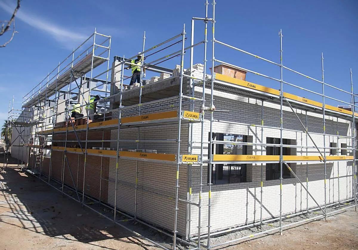 Un grupo de albañiles levantan un muro de ladrillos del módulo que albergará el grado medio de cocina y gastronomía.