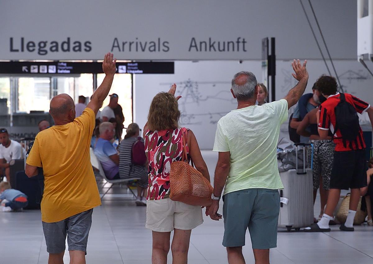 Imagen secundaria 1 - Izquierda: Amigos británicos saludan a una de las ocupantes del vuelo del Manchester que acaba de aterrizar. Derecha: La Oficina de Turismo atiende a «20 o 25 pasajeros por vuelo», según su coordinadora, aunque ese día bajó la media.