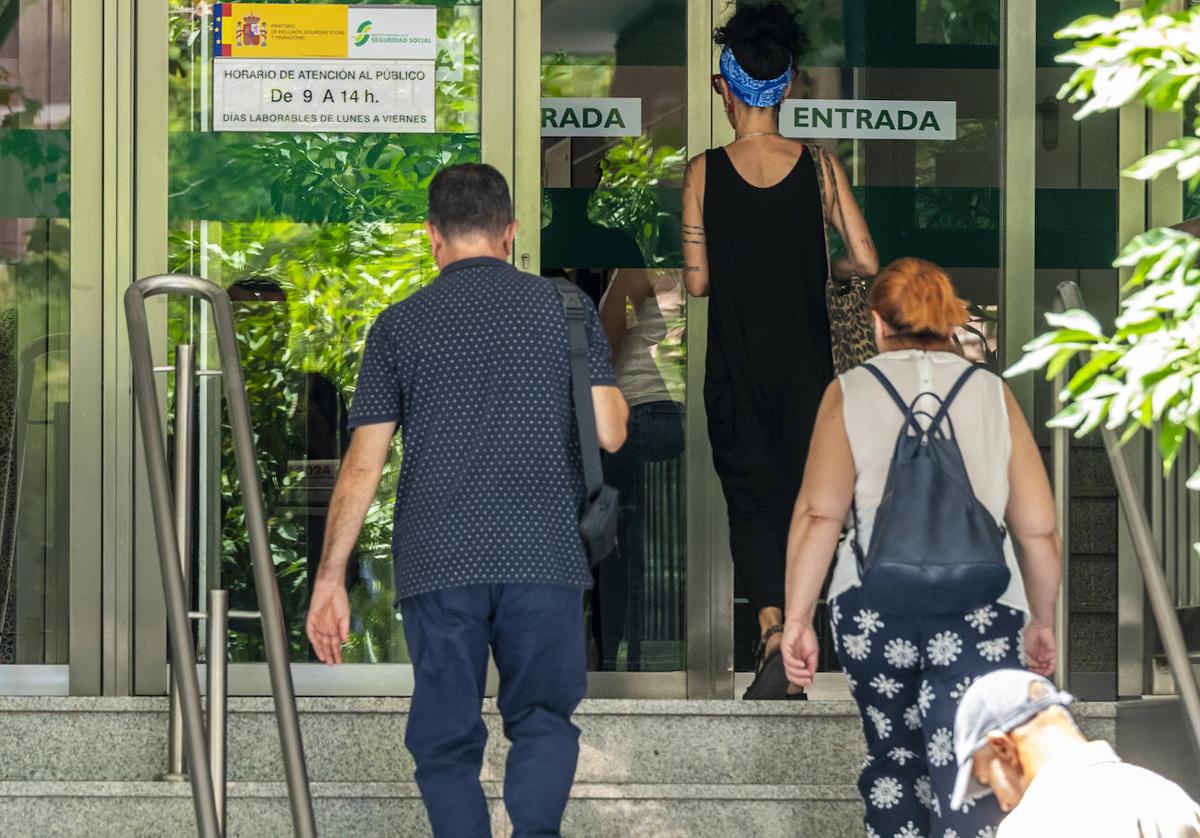 Tres personas acceden a las oficinas de la Seguridad Social en Murcia, en la calle Alfonso X.