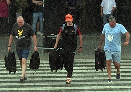 Tres personas cruzan un paso de cebra bajo un día de lluvia en Corvera, en una imagen de este mes de agosto.