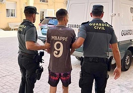 Dos agentes trasladan al presunto autor del robo en el aserradero de Moratalla.