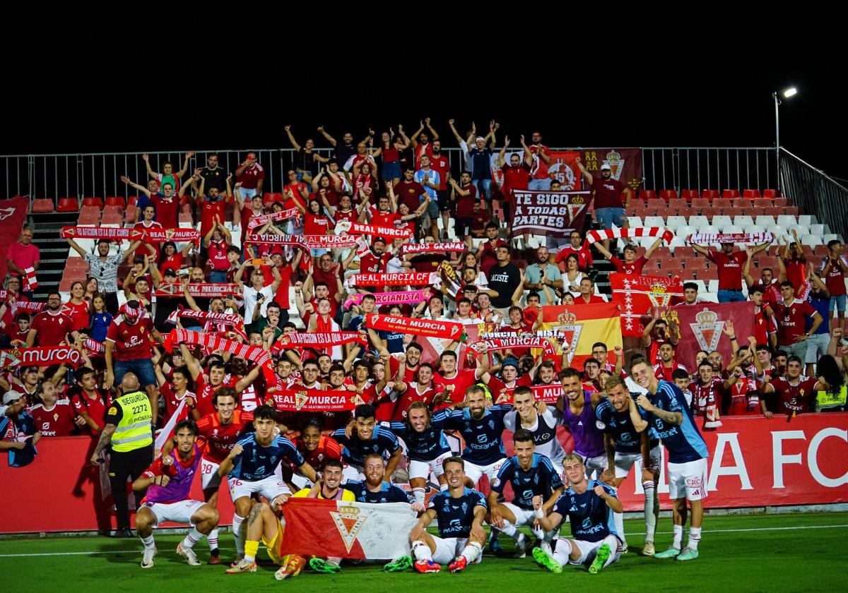 Los jugadores del Real Murcia posan con los aficionados tras la victoria en Sevilla, el pasado domingo.