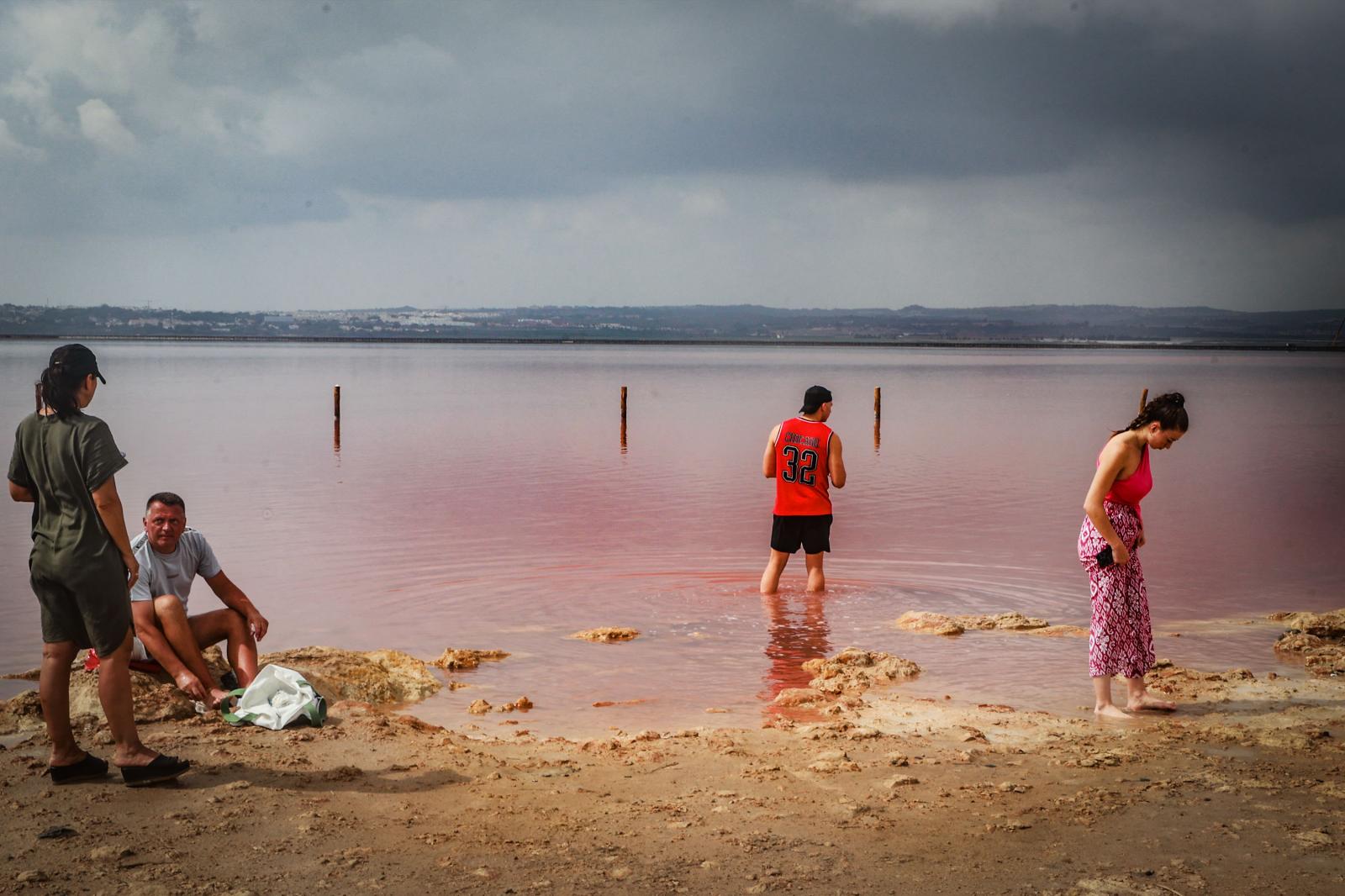 Los turistas toman las orillas de la Laguna Rosa de Torrevieja pese a la prohibición al baño